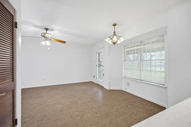 an empty room with fan and window