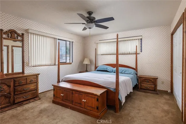 a bedroom with a bed and a dresser with wooden floor
