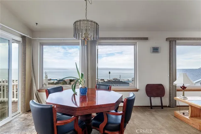 a dining room with furniture a chandelier and wooden floor