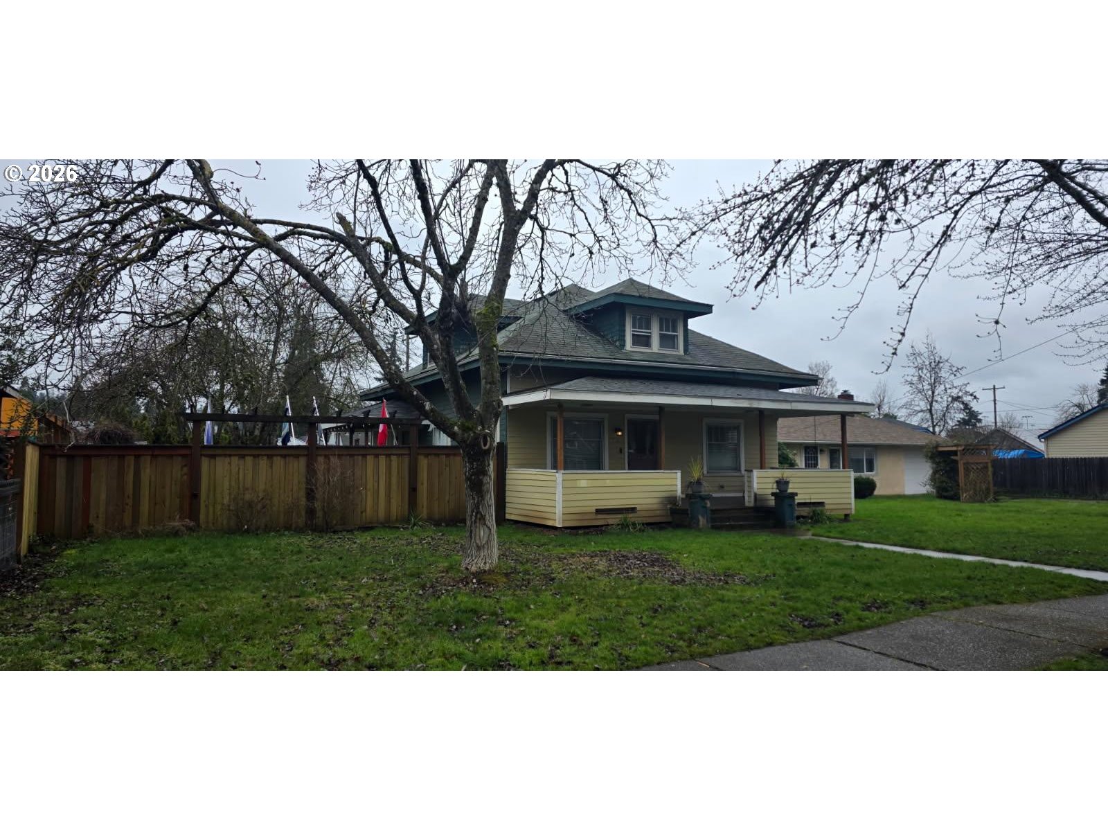 a view of a big house with a big yard and large trees