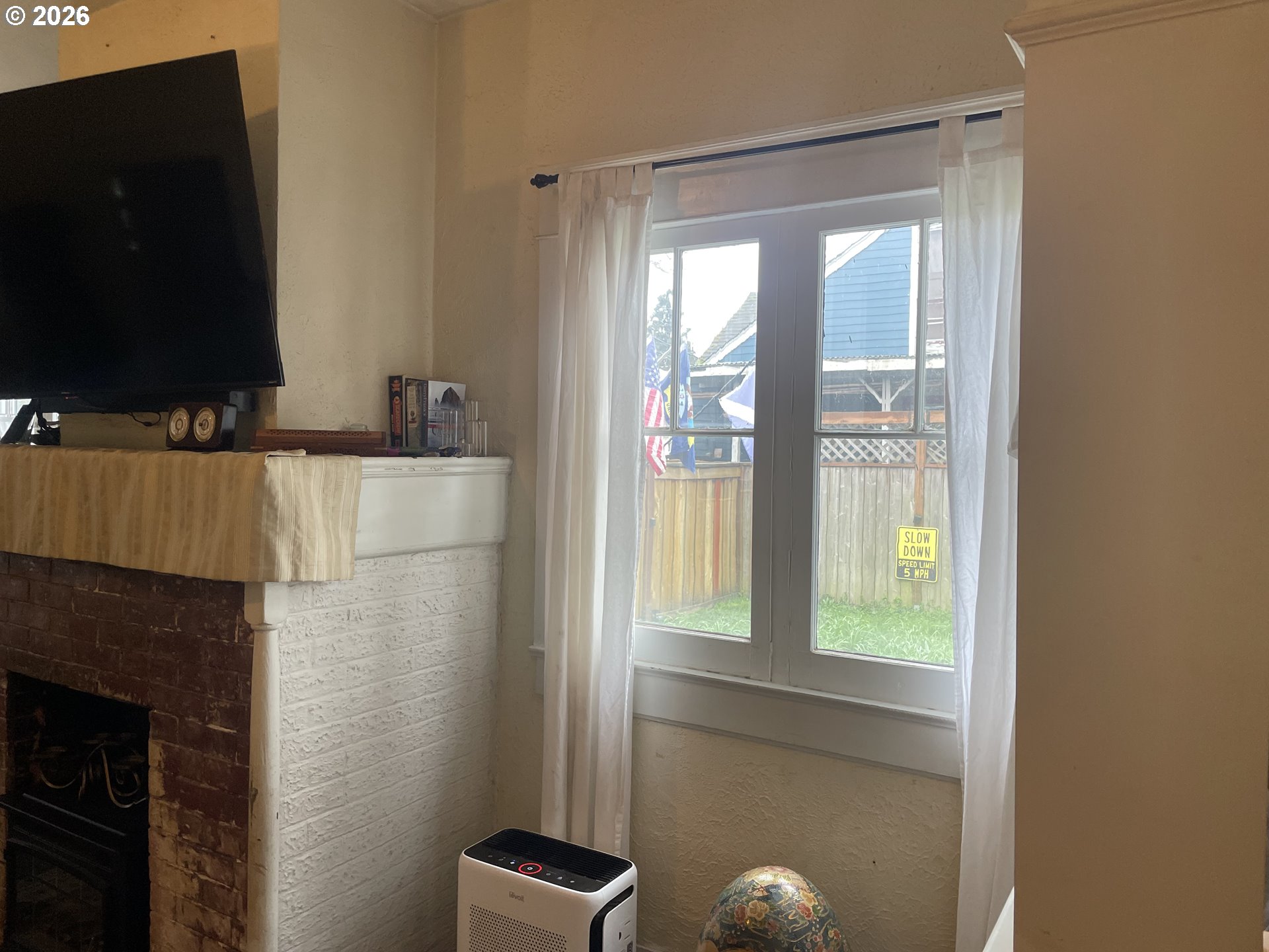 1006 5th Street Springfield, OR 97477 - Photo 8 of 43 a living room with a fireplace and a flat screen tv
