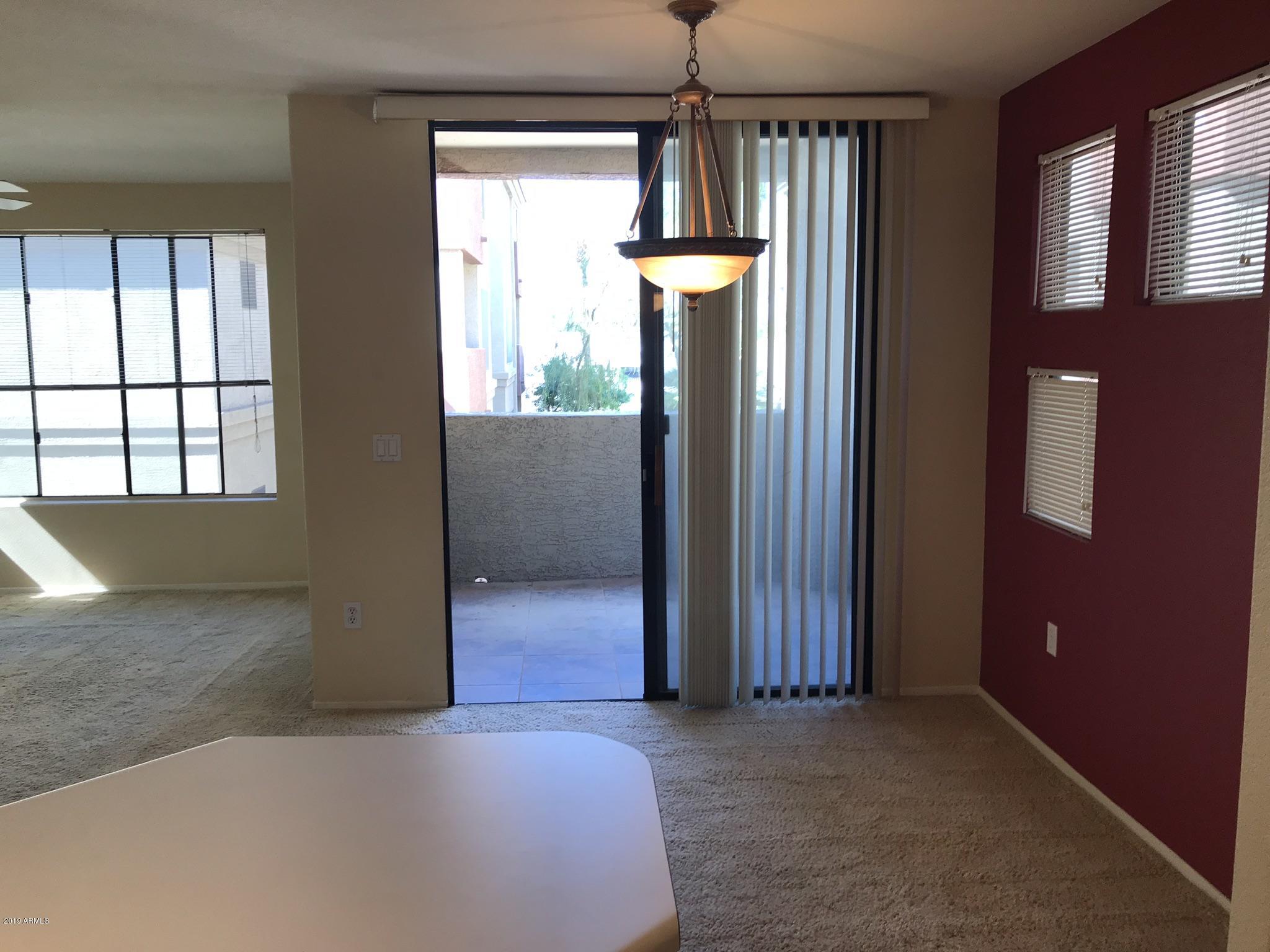 3848 North 3rd Avenue, Unit 2046 Phoenix, AZ 85013 - Photo 16 of 25 an empty room with chandelier fan and windows