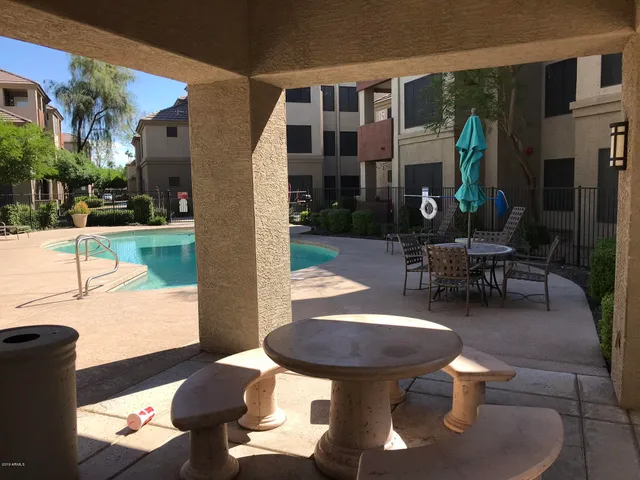 a view of a patio with dining table and chairs potted plants and a fountain