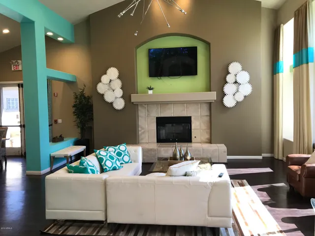 a living room with couches a fireplace and a flat screen tv