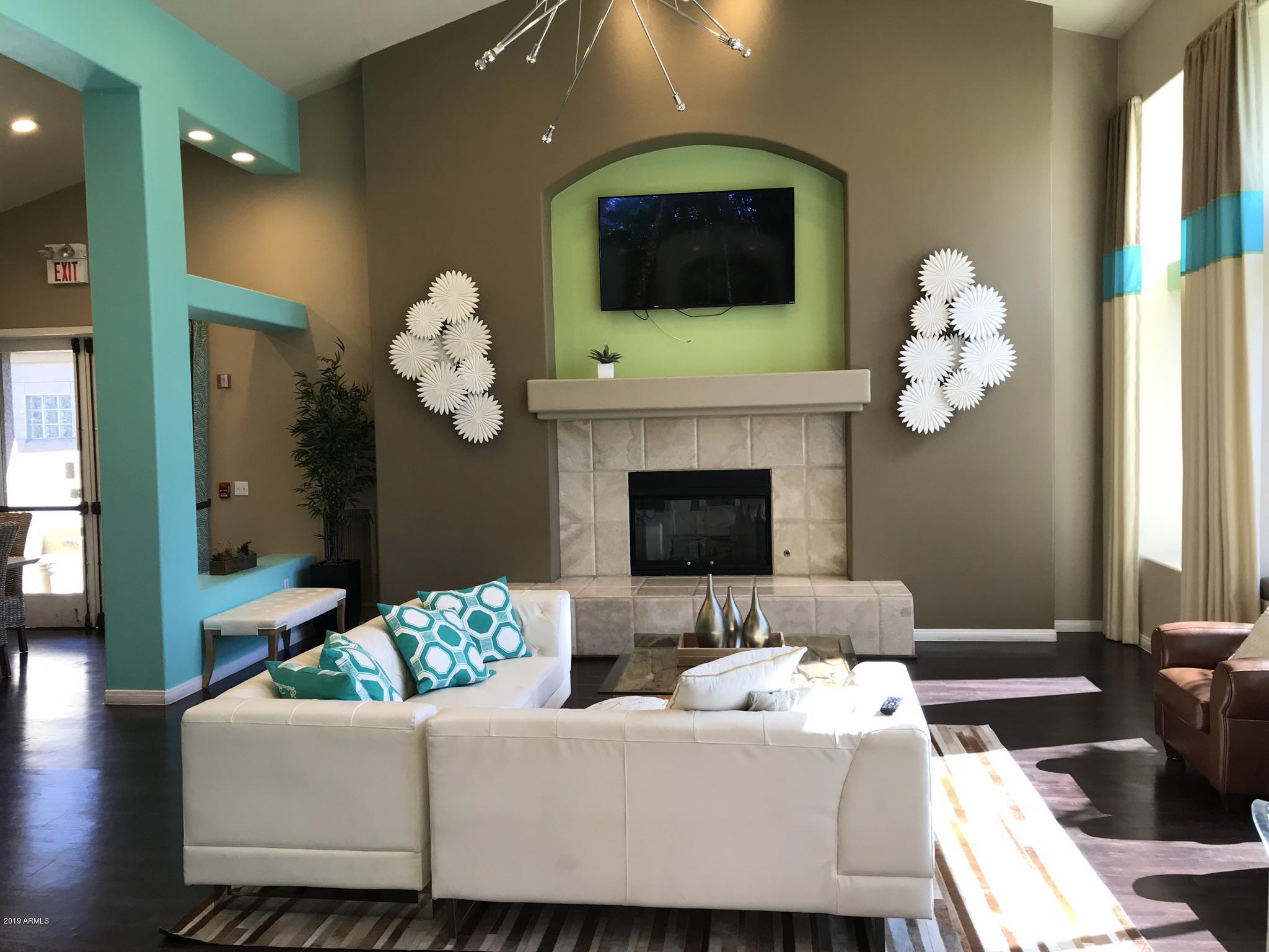 3848 North 3rd Avenue, Unit 2046 Phoenix, AZ 85013 - Photo 8 of 25 a living room with couches a fireplace and a flat screen tv