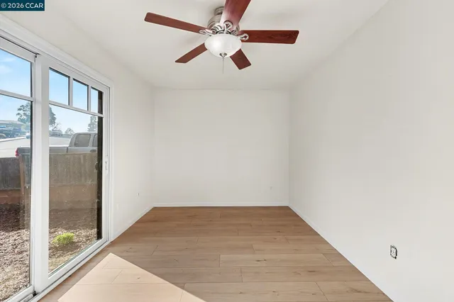 en empty room with windows and ceiling fan
