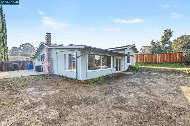 a view of a house with a yard and wooden fence