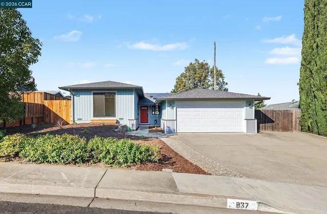 a front view of a house with a yard and potted plants