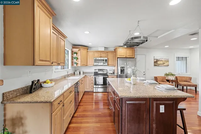 a kitchen with stainless steel appliances granite countertop a sink stove and refrigerator