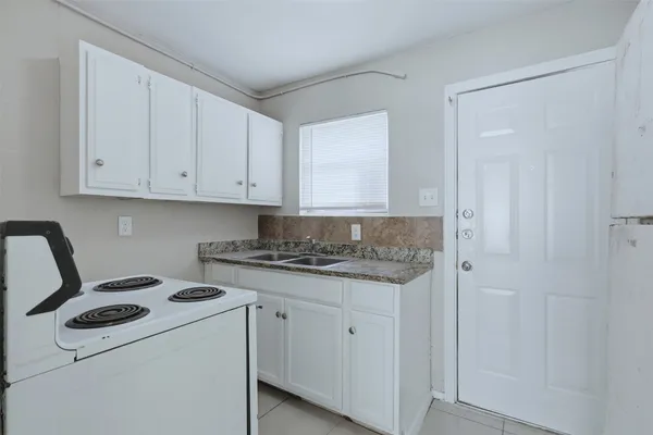 a kitchen with a stove and white cabinets