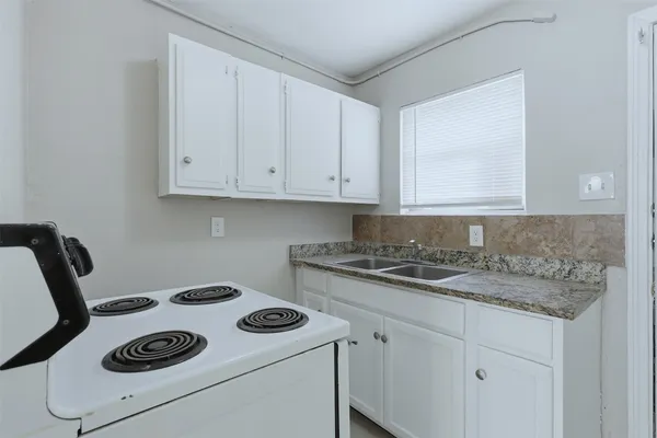 a stove top oven sitting inside of a kitchen