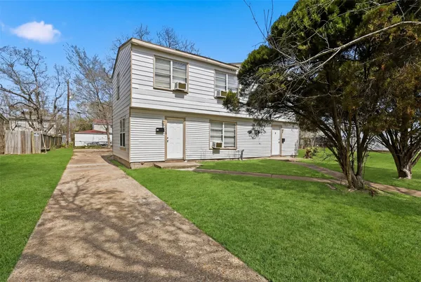 a view of a white house with a big yard and large tree