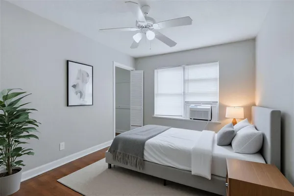 a bedroom with a large bed and a potted plant