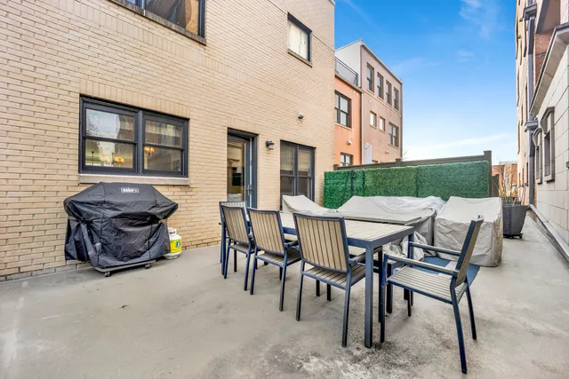 a view of a patio with table and chairs with wooden fence
