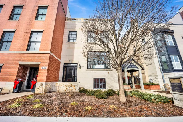 a view of a white house with a large tree