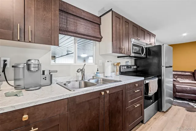 a kitchen with sink a microwave a refrigerator and cabinets