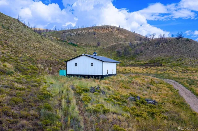 a view of a barn in the middle of a field