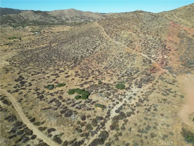 a view of a dry yard with mountains and green space