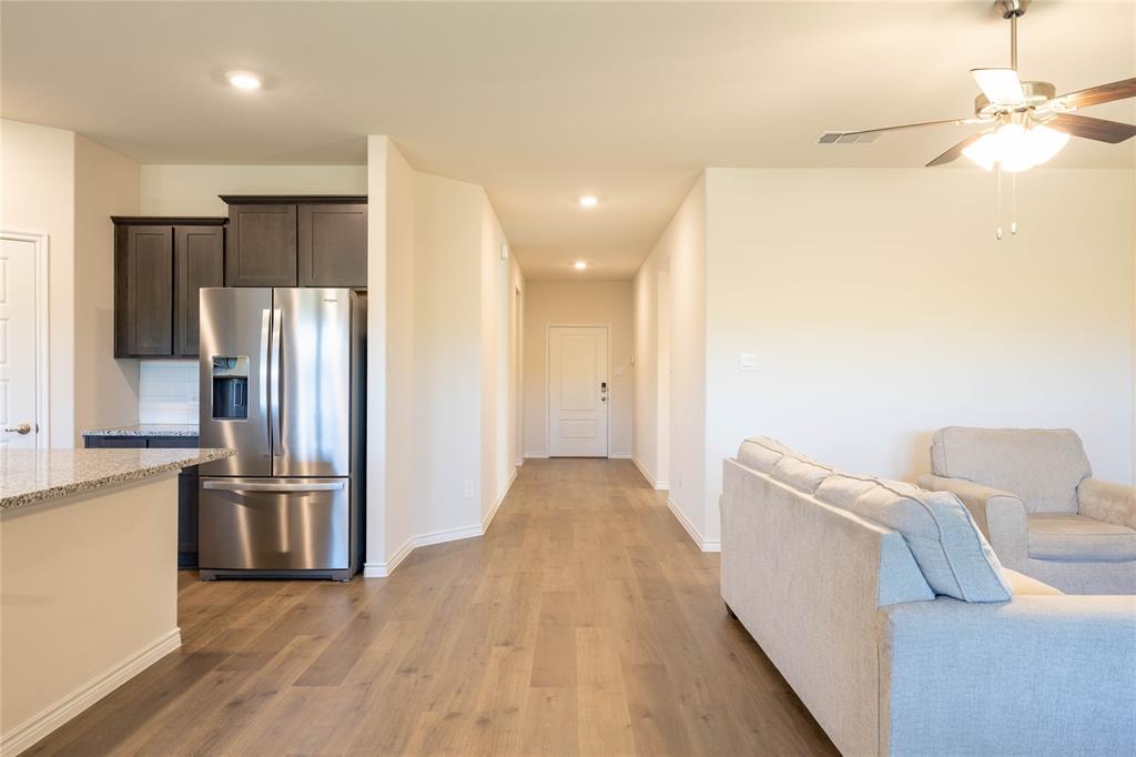 419 Revolution Road Fate, TX 75087 - Photo 5 of 19 a view of a kitchen with furniture and a refrigerator