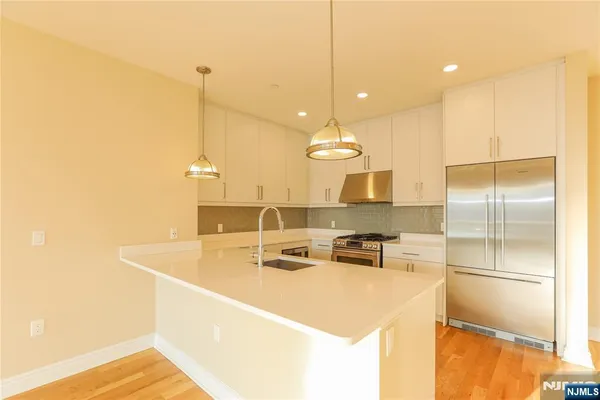 a kitchen with kitchen island a counter top space appliances and a ceiling fan