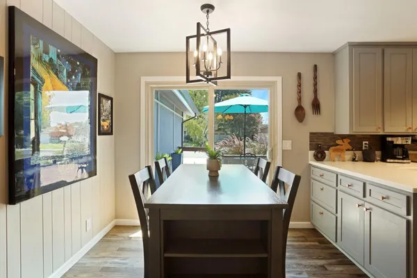 a dining room with furniture a chandelier and wooden floor