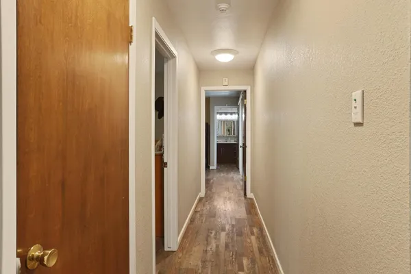 a view of a hallway with wooden floor