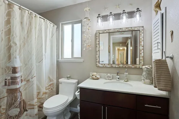 a bathroom with a sink vanity mirror and toilet