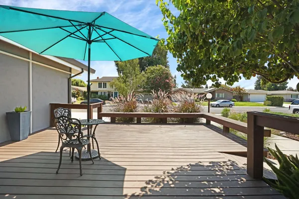 a view of a patio with dining table and chairs under an umbrella