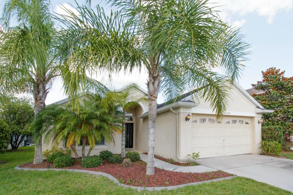 Wonderful curb appeal with swaying palm trees!