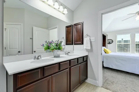 a en suite bathroom with a granite countertop sink and a mirror