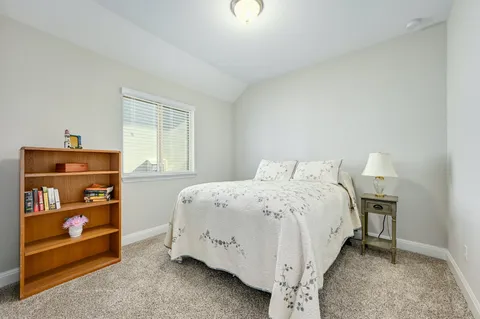 a bed sitting in a bedroom next to a window