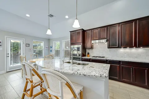 a kitchen with granite countertop a sink a counter top space appliances and cabinets