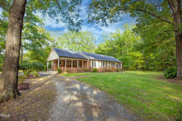 a view of a yard in front of a house with large trees