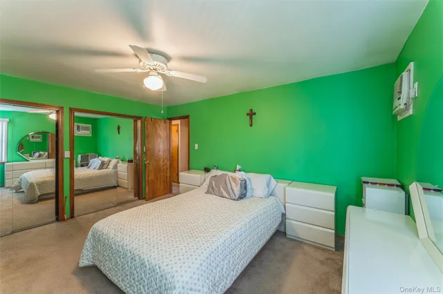 a bedroom with a bed mirror and window