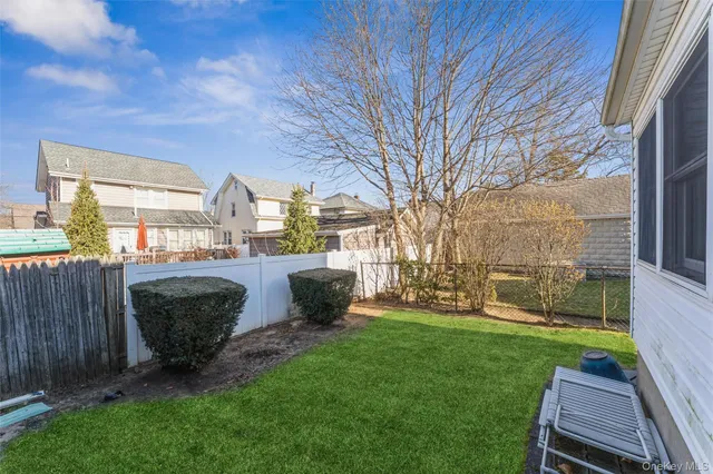 a view of a patio with table and chairs and wooden fence