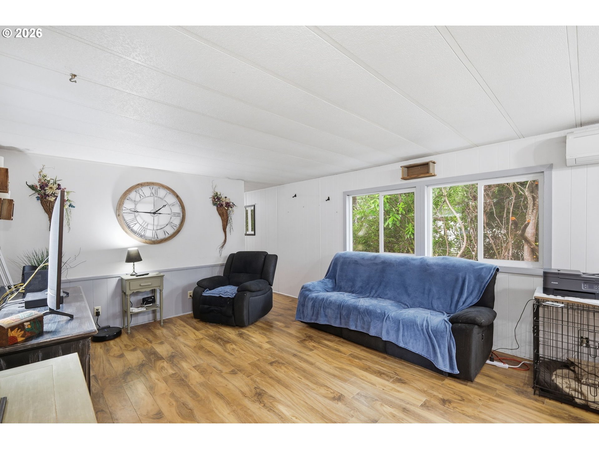 1600 Rhododendron Drive, Unit 76 Florence, OR 97439 - Photo 13 of 36 a living room with furniture a clock and a large window