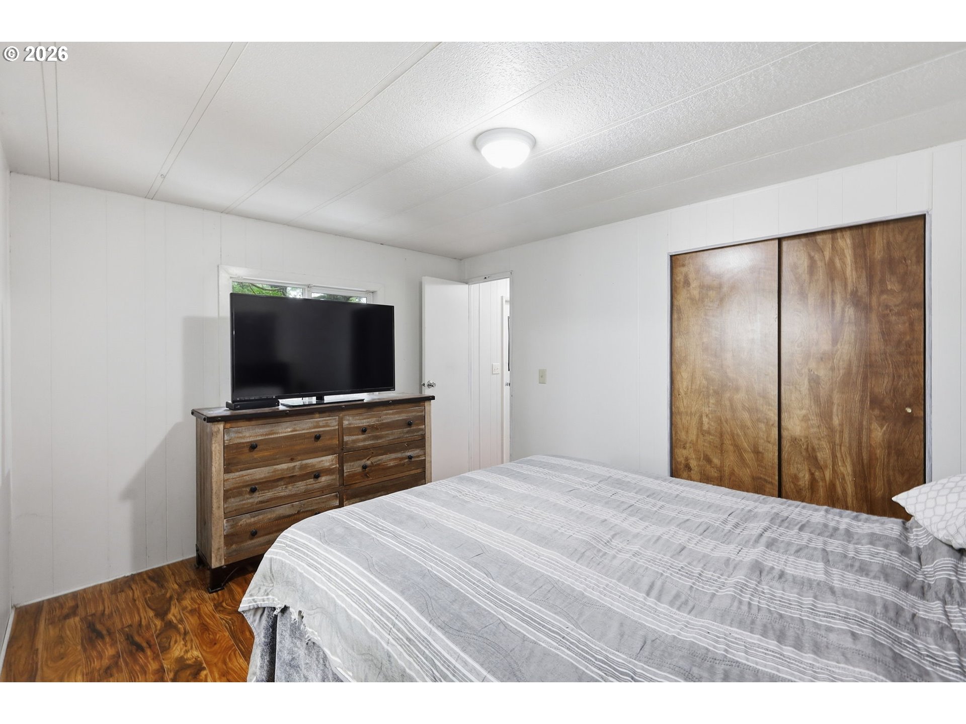 1600 Rhododendron Drive, Unit 76 Florence, OR 97439 - Photo 16 of 36 a bedroom with a bed and a flat screen tv