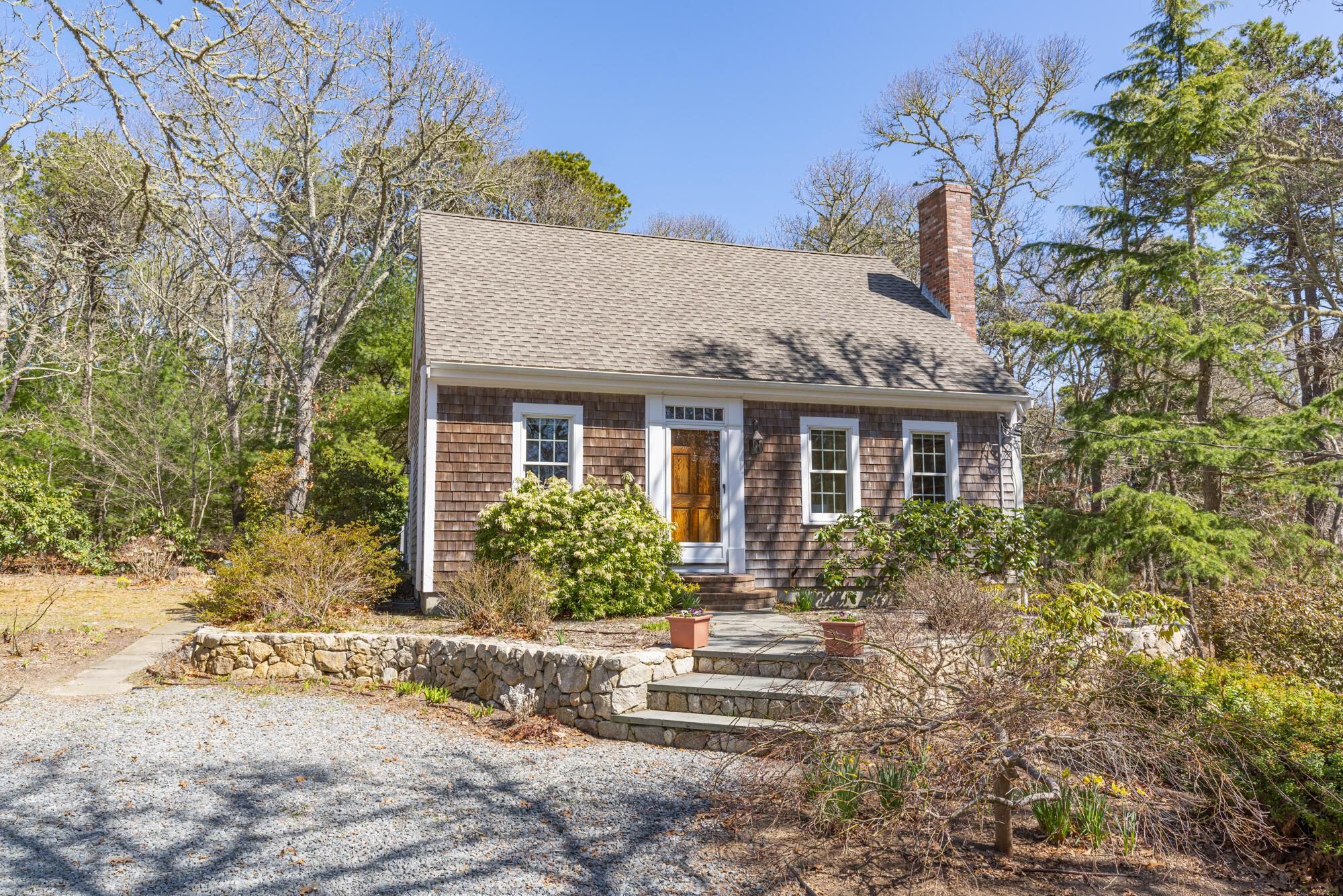 138 Namequoit Road Orleans, MA 02653 - Photo 32 of 50 a front view of a house with a yard and potted plants