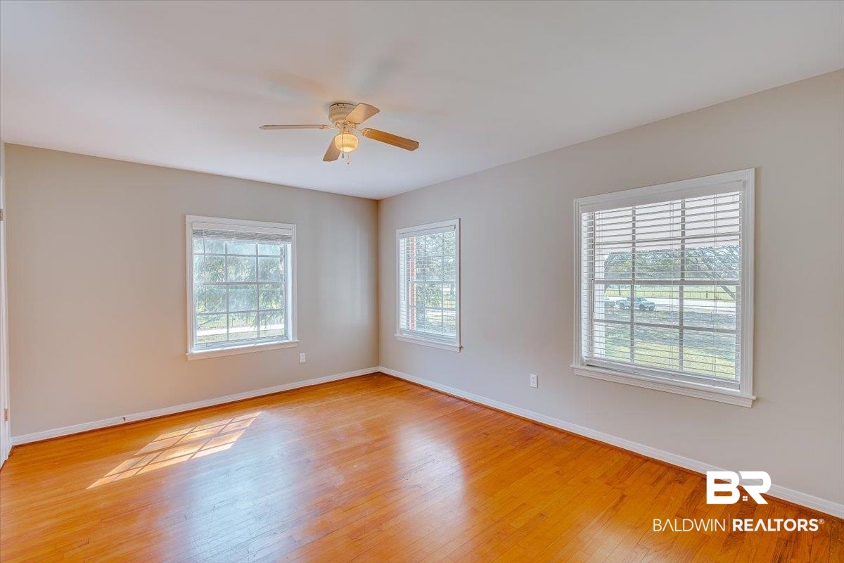 14160 Moffett Road Wilmer, AL 36587 - Photo 36 of 75 Unfurnished room featuring baseboards, light wood-style floors, and a ceiling fan