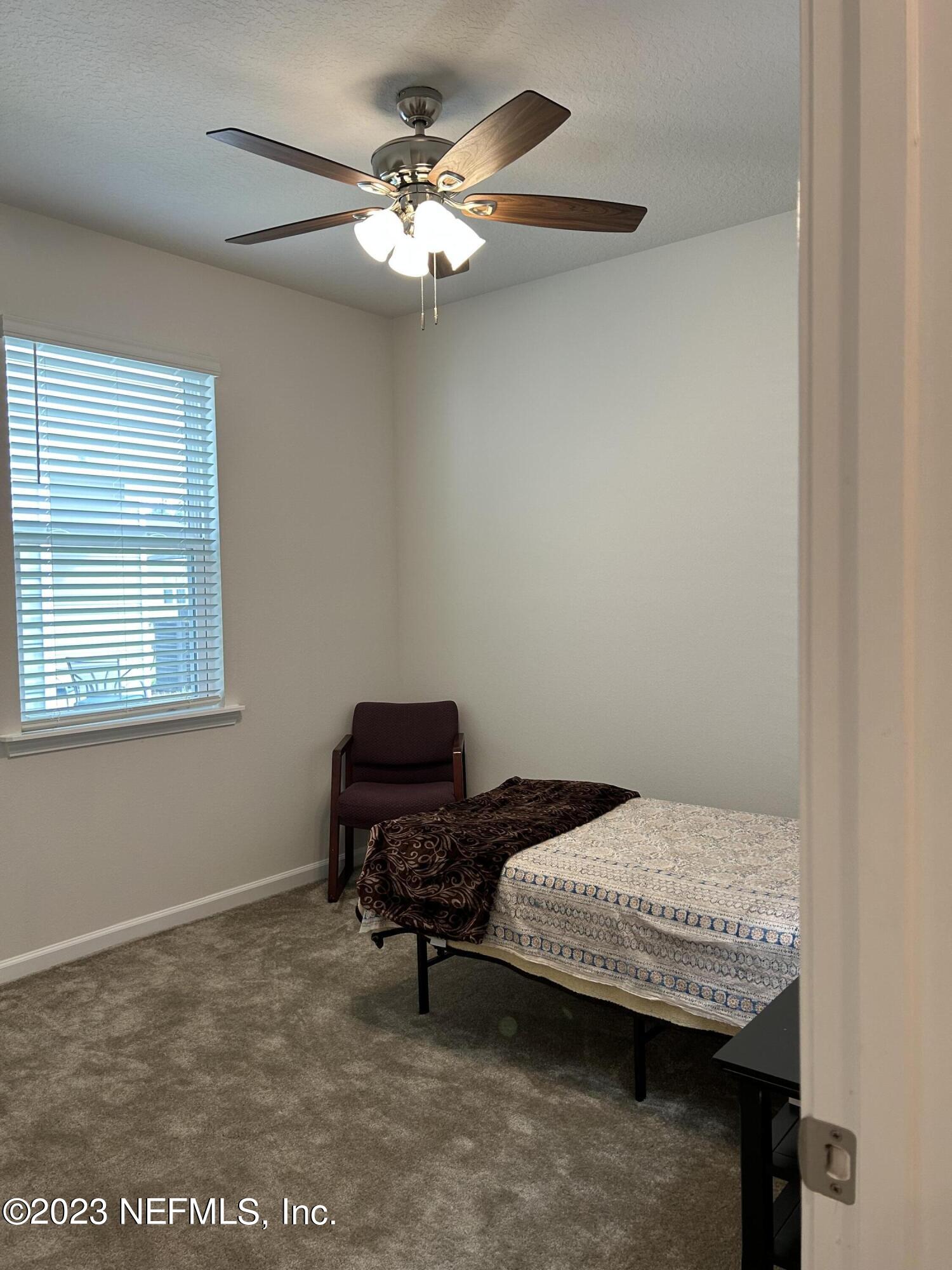 7109 Red Timber Road Jacksonville, FL 32244 - Photo 9 of 18 a bedroom with a bed and a chandelier