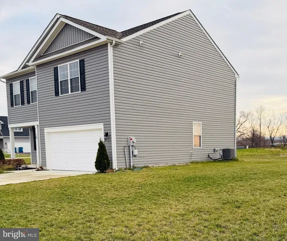 a view of a house with yard and garage