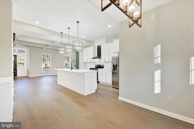 a view of a hallway with granite countertop wooden floor and a chandelier