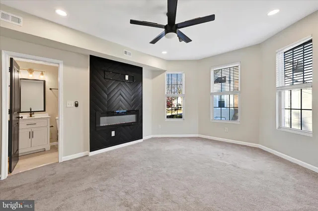 a view of an empty room with a window and a kitchen