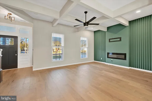 a view of an empty room with a window and a kitchen
