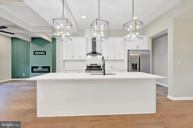 a large kitchen with kitchen island a chandelier and living room view