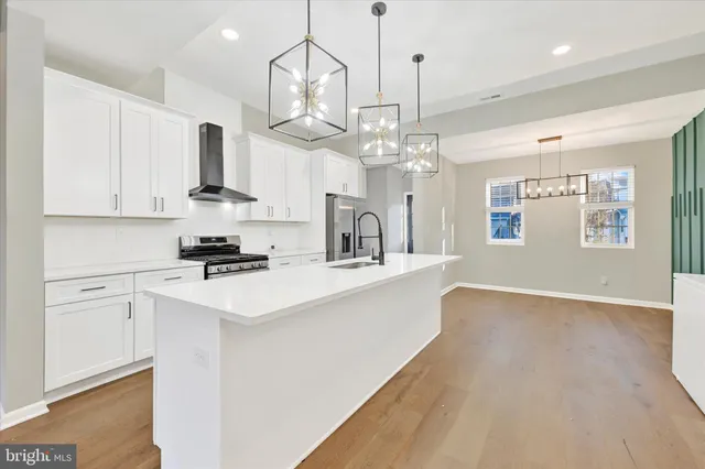 a kitchen with kitchen island stainless steel appliances sink cabinets and wooden floor