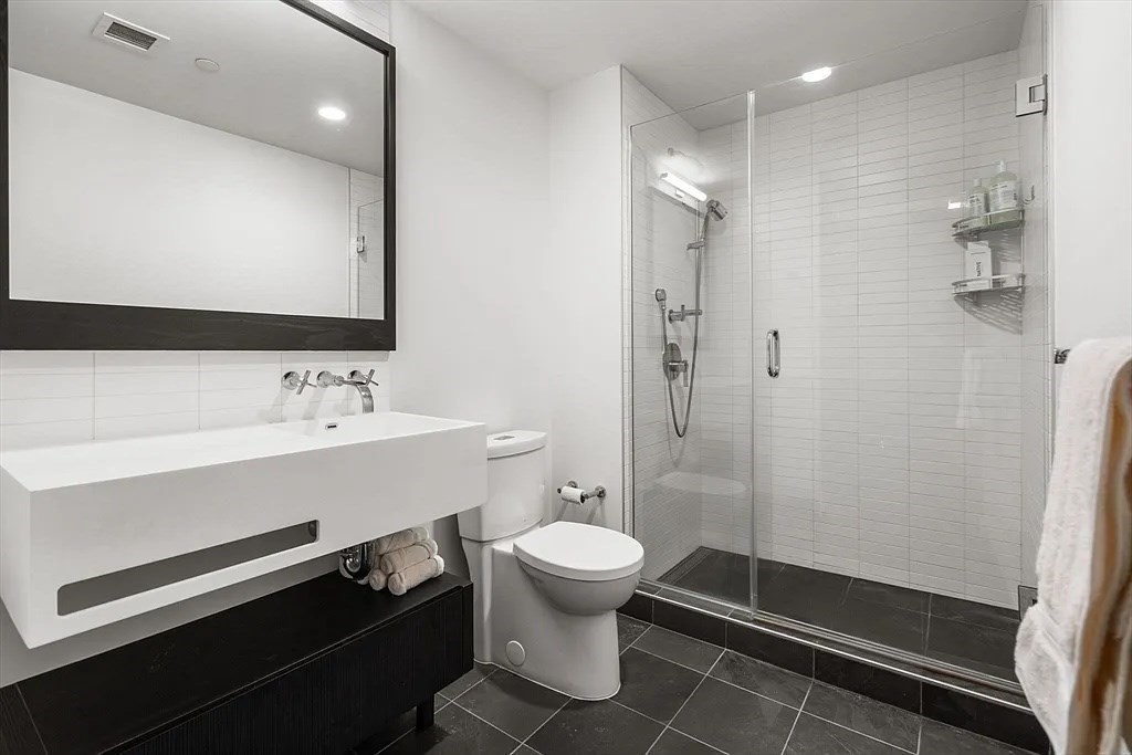 319 A Street, Unit 307 Boston, MA 02210 - Photo 14 of 25 a bathroom with a sink a toilet and shower