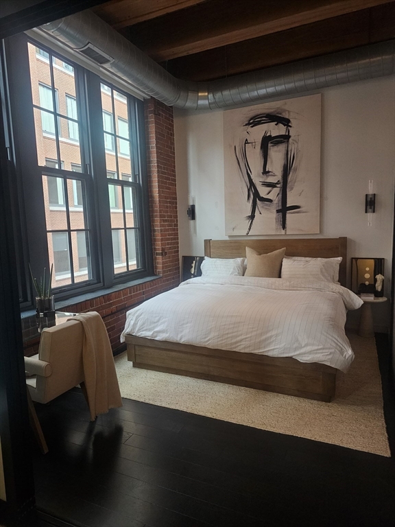 319 A Street, Unit 307 Boston, MA 02210 - Photo 5 of 25 a bedroom with a bed and wooden floor