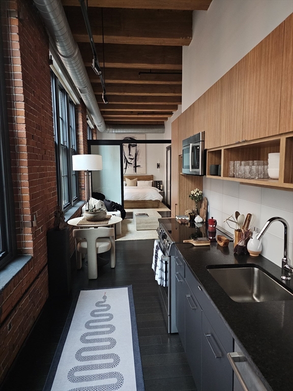319 A Street, Unit 307 Boston, MA 02210 - Photo 9 of 25 a kitchen with a sink appliances and cabinets