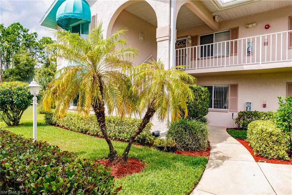 121 Gabriel Circle, Unit 1111 Naples, FL 34104 - Photo 1 of 34 a front view of a house with garden